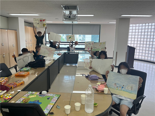 4회기 ‘나에 대한 질문 브루마블(6/1)’가 끝나고 아이들이 자신이 그린 가족사진과 찍은 사진 [사진=한국사회공헌협회 제공]