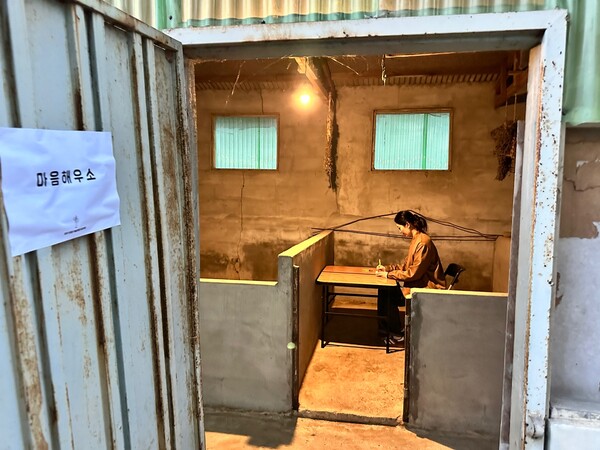 조문주 씨가 마음해우소에서 글을 쓰고 있다.