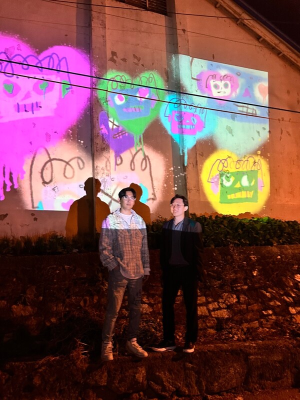 미디어 파사드를 배경으로 선 애니쿤(왼쪽) 작가와 심진우 박사.