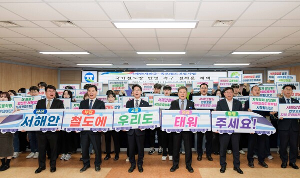 5개 지자체장과 관계자들 결의문 채텍후 가진 퍼포먼스에서 서해안 철도에 우리도 태워 주세요 라고 쓰인 손 프랑을 들고 외치며 결의를 다지고 있다(사진=영광군 제공)