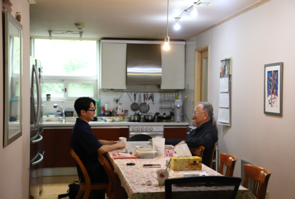 이문동 집에서 최의광 씨와 박동현 씨가 식탁에 앉아 대화를 나누고 있다. (사진=이성현)