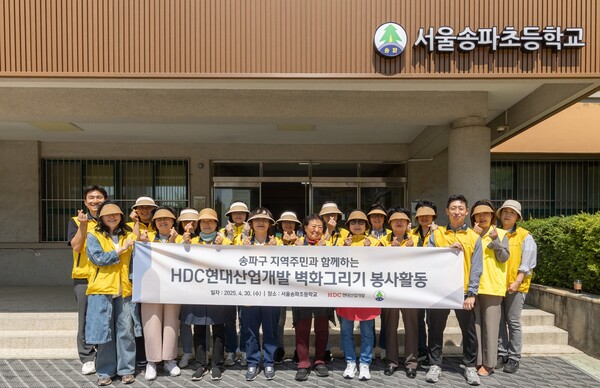 HDC현대산업개발은 도시정비부문 직원과 지역주민 등 20여 명이 참석한 가운데 서울송파초등학교의 외벽 담장 벽화를 새롭게 그리는 봉사활동을 진행 후 기념사진을 촬영하고 있다. [사진=HDC현대산업개발]