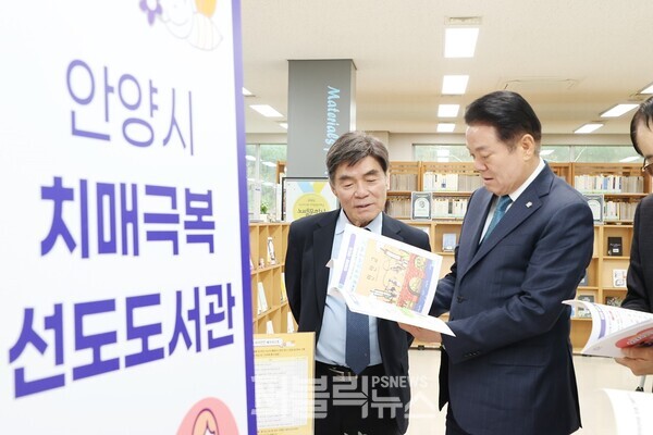 지난 4월 9일 석수도서관에서 열린 치매극복 선도도서관 지정 현판식에 참석한 최대호 안양시장이 도서를 살펴보고 있다.[사진=안양시]