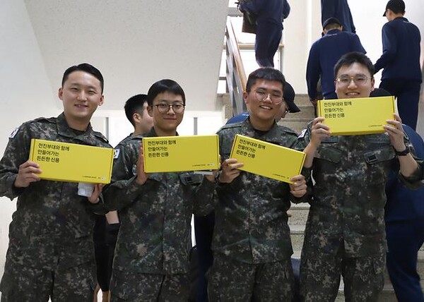 신용회복위원회는 5월 15일 육군본부와 함께 전진부대에서 군 장병을 대상으로 '전진부대와 함께 만들어가는 든든한 신용' 행사 중 응원키트를 받고 기념사진을 촬영하고 있는 모습. [사진=신용회복위원회]